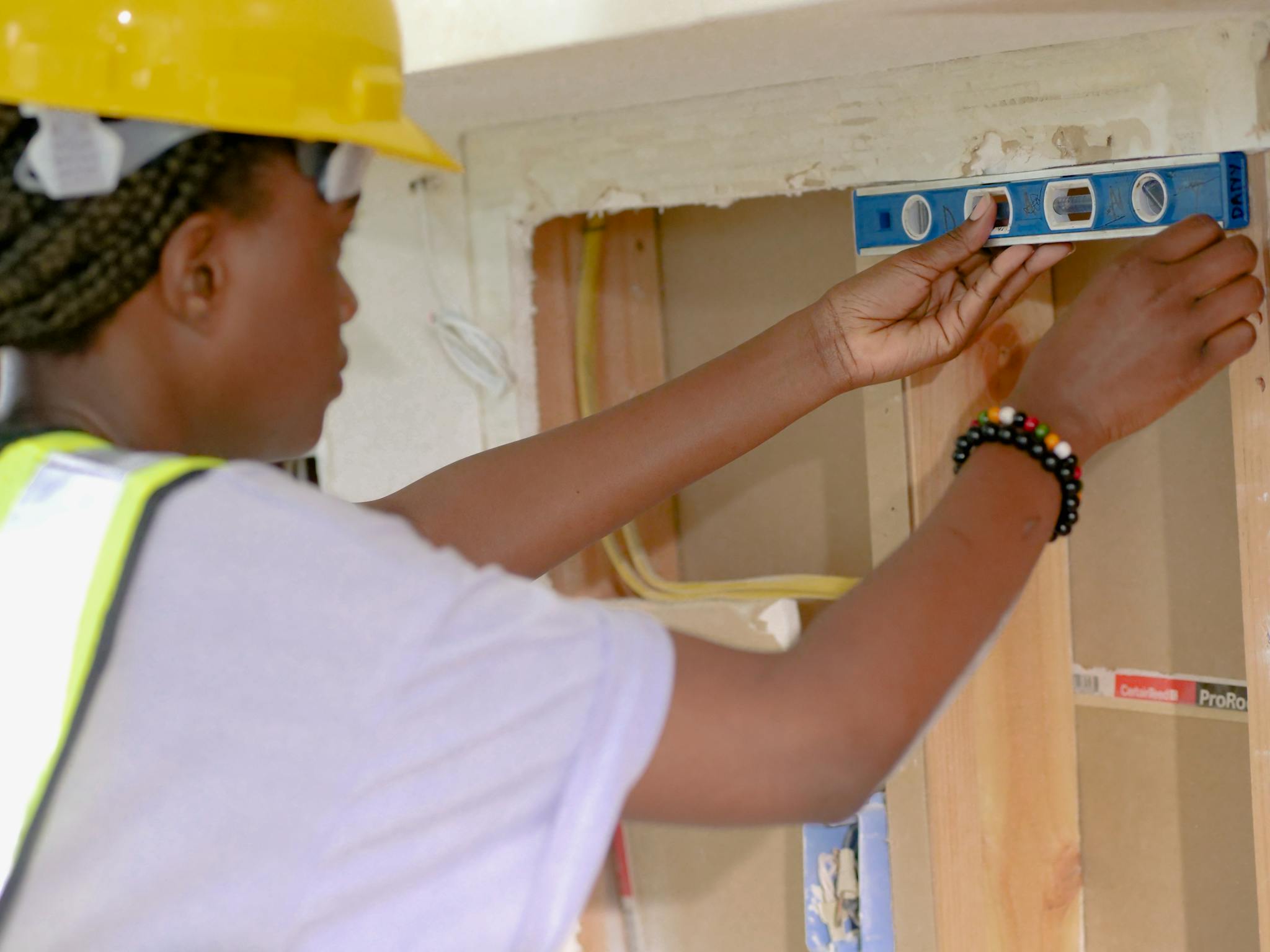 A construction worker accurately aligns using a level inside a building project.