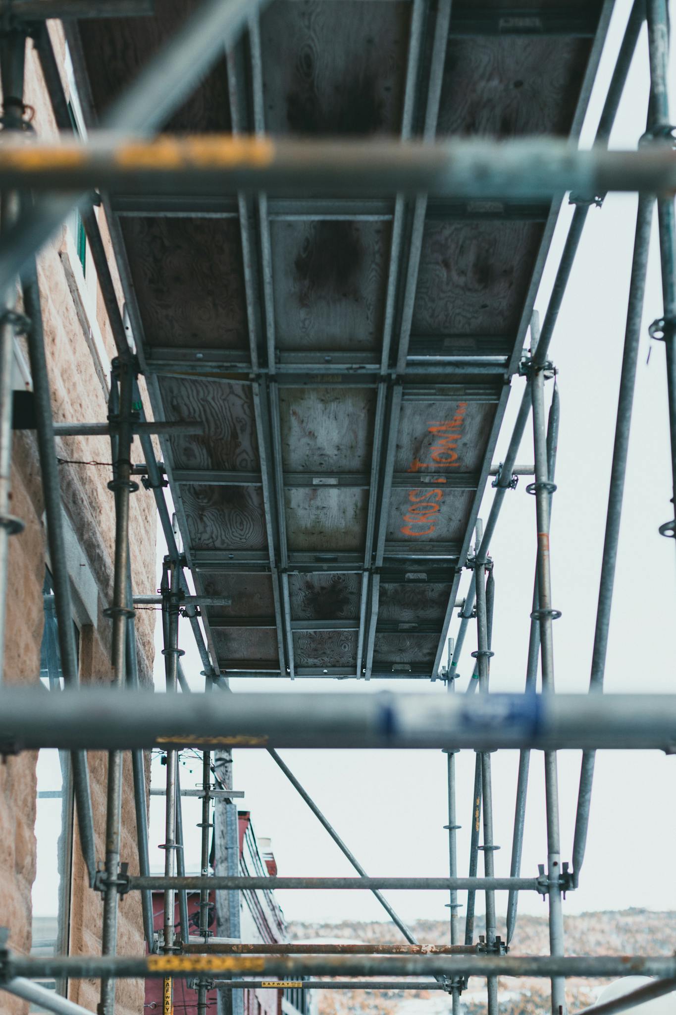 A vertical shot of metal scaffolding used for construction work, emphasizing safety and structure.